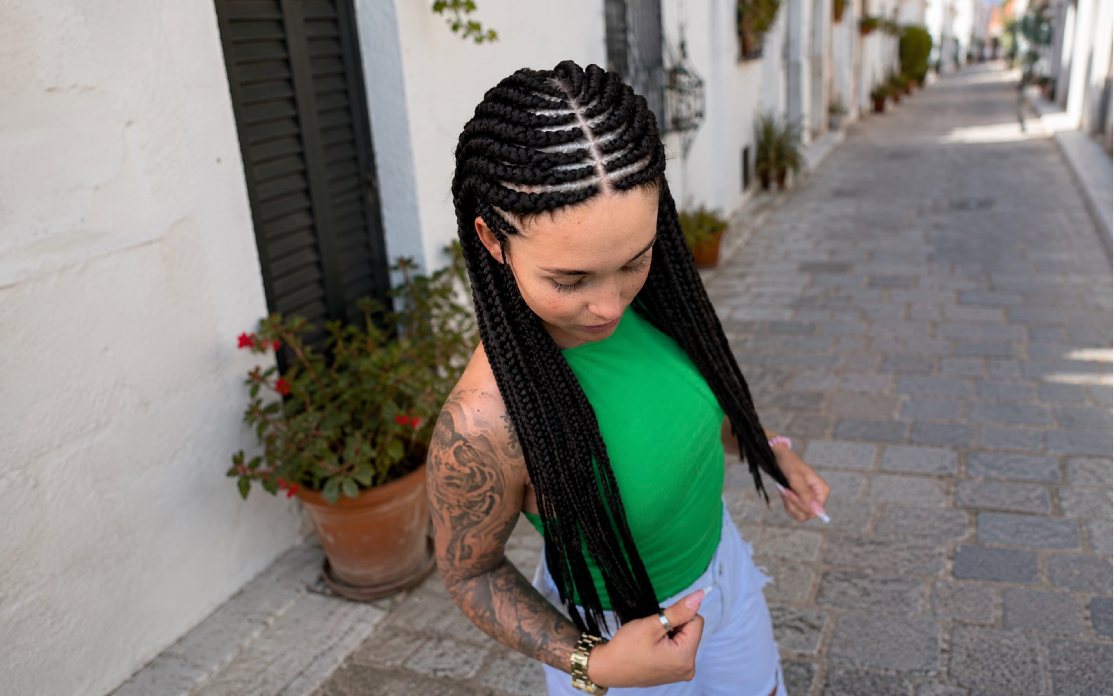 Zapletené cornrow copánky přecházející do dlouhých pramenů